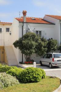 a car parked in a parking lot in front of a house at Apartments by the sea Postira, Brac - 5660 in Postira