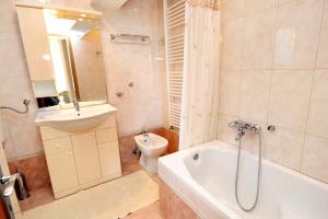 a bathroom with a tub and a sink and a toilet at Apartments by the sea Klenovica, Novi Vinodolski - 5580 in Klenovica