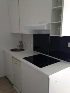 a white kitchen with a sink and a counter top at Apartments by the sea Dramalj, Crikvenica - 5597 in Dramalj