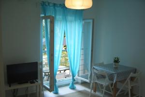 a room with a table and a window with blue curtains at Apartments by the sea Dramalj, Crikvenica - 5597 in Dramalj