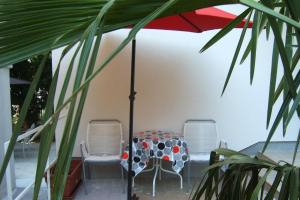 a table and chairs under an umbrella on a patio at Apartments by the sea Dramalj, Crikvenica - 5597 in Dramalj