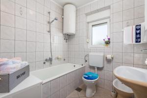ein Badezimmer mit Badewanne, Toilette und Waschbecken in der Unterkunft Apartments by the sea Klenovica, Novi Vinodolski - 5575 in Klenovica