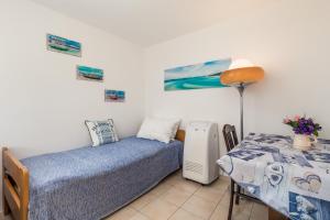 1 Schlafzimmer mit 2 Einzelbetten und einem Tisch mit einer Lampe in der Unterkunft Apartments by the sea Klenovica, Novi Vinodolski - 5575 in Klenovica