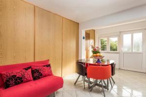 ein Wohnzimmer mit einem roten Sofa und einem Tisch in der Unterkunft Apartments by the sea Klenovica, Novi Vinodolski - 5575 in Klenovica