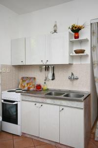 una cocina con armarios blancos y fregadero en Apartments with a parking space Jadranovo, Crikvenica - 5533, en Jadranovo