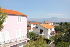 a group of houses on a hill with mountains in the background at Apartments with parking space Supetar, Brac - 5653 in Supetar +15 photos