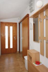 a bathroom with a toilet and a wooden door at Apartments with parking space Supetar, Brac - 5653 in Supetar