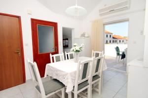 cocina y comedor con mesa y sillas en Apartments and rooms with parking space Supetar, Brac - 5658, en Supetar