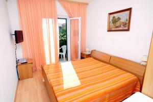 Habitación de hotel con cama y balcón en Apartments and rooms with parking space Supetar, Brac - 5658 en Supetar