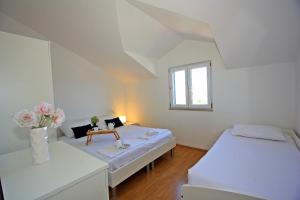una habitación con 2 camas y una mesa con flores en Apartment Supetar 5662b, en Supetar