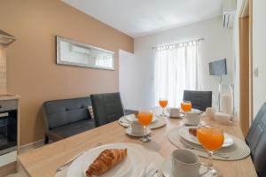 - une salle à manger avec une table, de la nourriture et du jus d'orange dans l'établissement Apartments by the sea Nin, Zadar - 5666, à Nin