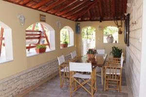 a dining room with a table and chairs and windows at Family friendly house with a swimming pool Postira, Brac - 5661 in Postira