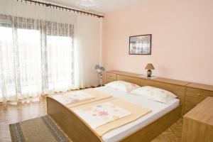 a bedroom with a bed and a large window at Apartments with a parking space Dramalj, Crikvenica - 5576 in Dramalj