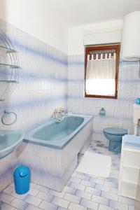 a bathroom with a blue tub and a toilet at Apartments with a parking space Dramalj, Crikvenica - 5576 in Dramalj