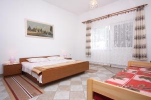 Schlafzimmer mit einem Bett und einem Fenster in der Unterkunft Apartments with a parking space Krk - 5364 in Krk