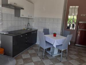 eine Küche mit Tisch und Stühlen und einer Spüle in der Unterkunft Apartments with a parking space Krk - 5364 in Krk