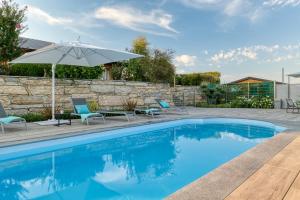 een zwembad met stoelen en een parasol bij I Boschetti in Magliano Alpi