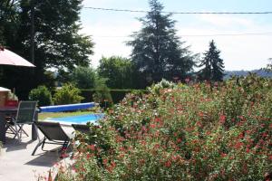 a garden with a swimming pool and flowers at Maudon Coeur de Baie in Ponts
