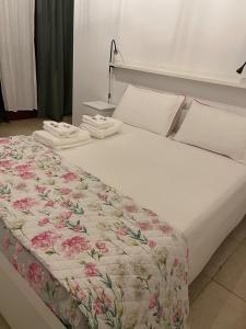 een wit bed met een bloemendekbed erop bij #soloperte B&B apartments in Molfetta