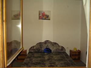 ein Schlafzimmer mit einem Spiegel und einem Bett mit einem blauen Kissen in der Unterkunft Szigeti B&B in Bogács