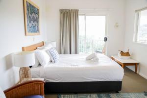 En eller flere senge i et værelse på 15 Whale Watch Resort + Beach Front + Ducted Air Con + 3 Bed + 2 Bath