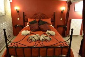 een slaapkamer met een bed met rode muren bij B&B Noord-Zuid in Zonhoven