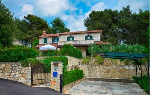 une maison avec un portail et une clôture en pierre dans l'établissement Stunning Home In Sveti Lovrec With Wifi, à Sveti Lovreč Pazenatički