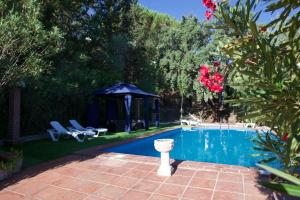 una piscina en un patio con cenador en CASA RURAL SANTA ELENA, en Cazalla de la Sierra