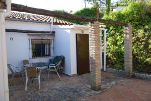 un patio con mesa y sillas frente a una casa en CASA RURAL SANTA ELENA, en Cazalla de la Sierra