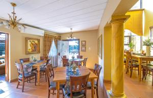 une salle à manger avec des tables et des chaises en bois dans l'établissement Sunward Park Guest House & Conference Center, à Boksburg