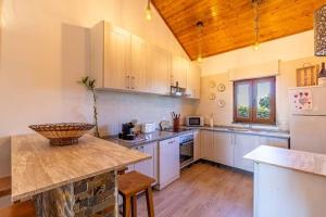 cocina grande con electrodomésticos blancos y techo de madera. en Casa de São bento - Monsaraz, en Monsaraz