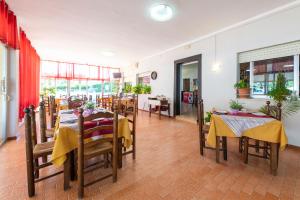 - un restaurant avec des tables et des chaises dans une salle dans l'établissement Bungalows Camping el Cid, à Peñíscola