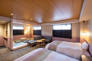 a hotel room with two beds and a living room at Rinn Gion Yasaka in Kyoto