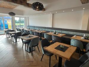 a restaurant with rows of tables and chairs at Sporthotel Dorum in Dorum