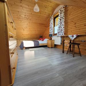 sypialnia z łóżkiem w drewnianym domku w obiekcie Na Szlaku - domki do wynajęcia w Rabce