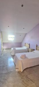 a room with three beds with white sheets at Duplex centro Lidia in Ronda