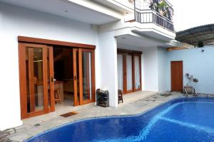 a house with a swimming pool next to a building at Villa Bale Damai Denpasar in Seminyak