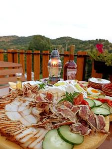 een bord met vlees en groenten op tafel bij Lesnovo House Tomevski in Lesnovo
