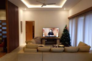 a living room with a couch and a christmas tree at Villa Bale Damai Denpasar in Seminyak