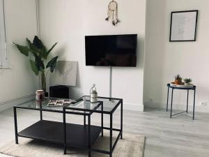 a living room with a glass table and a tv at Appartement Duplex La Cambu'z Le Portel Plage in Le Portel