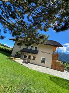 un grande edificio bianco con tetto di Schönhuberhof Apartment Panoramablick a Brunico