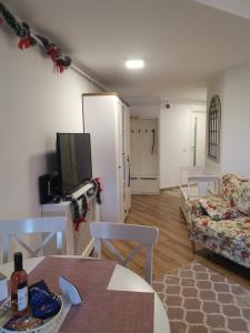 sala de estar con sofá, mesa y TV en Apartament Dragoste și Lavandă Sinaia, en Sinaia