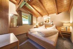 ザールバッハ・ヒンターグレムにあるBoutique Appartementsの木製の天井が特徴のベッドルーム1室(ベッド1台付)