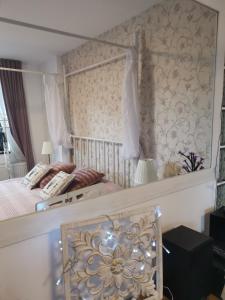 1 dormitorio con 1 cama con papel pintado de flores en Apartament Dragoste și Lavandă Sinaia, en Sinaia