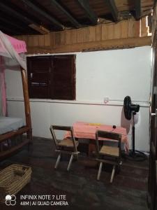 una camera con tavolo, macchina fotografica e letto di Mida Creek Eco Camp - cottage house a Mida