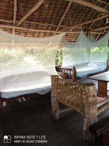 una camera con due letti e un'amaca in esso di Mida Creek Eco Camp - cottage house a Mida