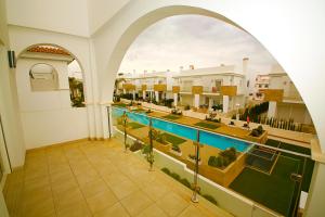 einen Torbogen in einem Gebäude mit einem Pool in der Unterkunft Luxury bungalow Allegra 43 with AC and Pool in Ciudad Quesada