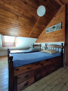 a bed in a room with a wooden ceiling at La Belle Escale in Gap