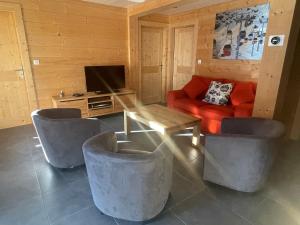 sala de estar con sofá rojo y TV en Modern Comfortable Chalet with large terrace en Morzine