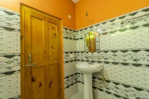 a bathroom with a sink and a door at Venky's Place in Jibhi +74 photos